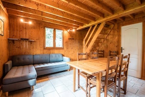 Un interno in legno con un divano, un tavolo da pranzo, sedie e una scala.