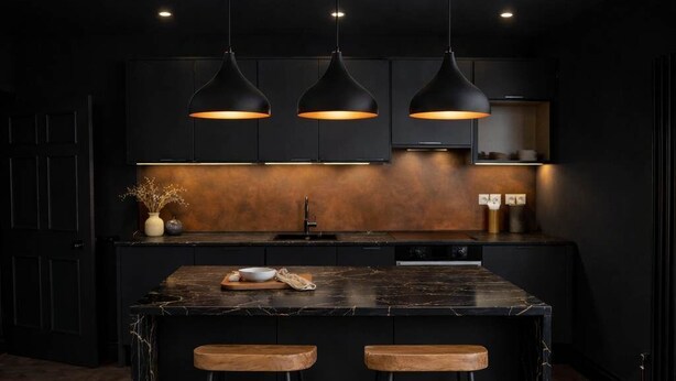 A modern kitchen with a dark color scheme, three pendant lights, a central island with stools, and a herringbone wood floor. - The Bridge York - Stunning River Front Location (York)