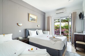 A hotel room with two beds, a desk, a chair, a TV, and a view of the outdoors. - Room 'Double  118' with Shared Terrace, Wi-Fi and Air Conditioning (Nikiana)