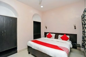 A bedroom with a bed, a wardrobe, and a nightstand. - SHREE KRISHNA HOTEL INN (Varanasi)