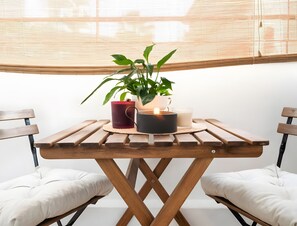 Uma mesa de madeira com uma vela, uma planta e um copo de leite.