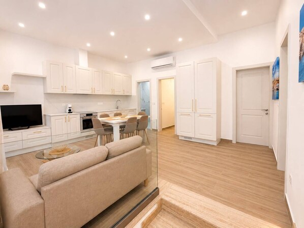 A modern apartment with a kitchen, dining area, and living room. - Maisonette 2 Bedroom in quaint Qala with AC for relaxing stays next to Square (Qala)