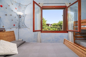 Ein Schlafzimmer mit einem Bett, einem Fenster, einer Lampe und einer Wand mit netzartiger Dekoration.