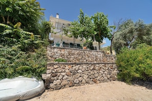 A stone wall, a white inflatable pool, and a building with a balcony. - Secret Beach B Apartment with Sea View, Wi-Fi, and Air Conditioning (Nikiana)