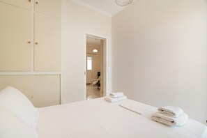 A hotel room with a bed, a wardrobe, and a view into another room. - Secret Beach B Apartment with Sea View, Wi-Fi, and Air Conditioning (Nikiana)