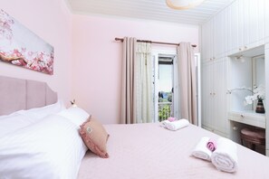 Ein Schlafzimmer mit einem Bett, einem Nachttisch, einem Spiegel und einem Fenster mit Vorhängen.