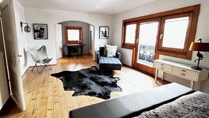 Una camera da letto con un letto, un tappeto in pelle nera, una scrivania, una sedia e una finestra.