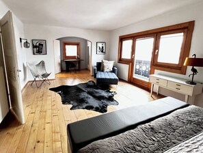 A bedroom with a bed, a black leather rug, a desk, a chair, and a window. - 4 Season Lodge by Belle-Stay for 8 people with a stunning view (Zell am See)
