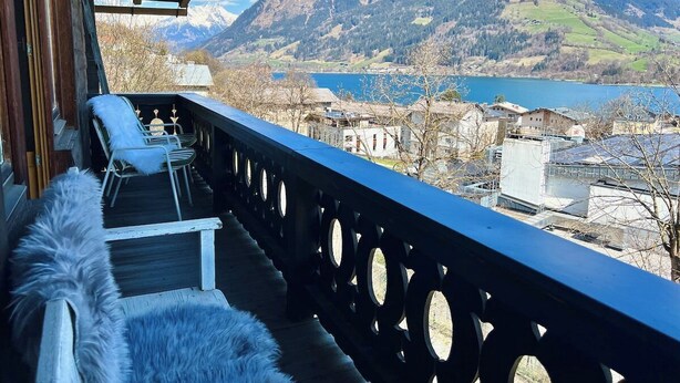 Un balcone con vista su montagne e un lago.