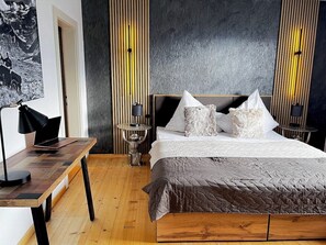 Ein Schlafzimmer mit einem Bett, einem Schreibtisch und einem Nachttisch.