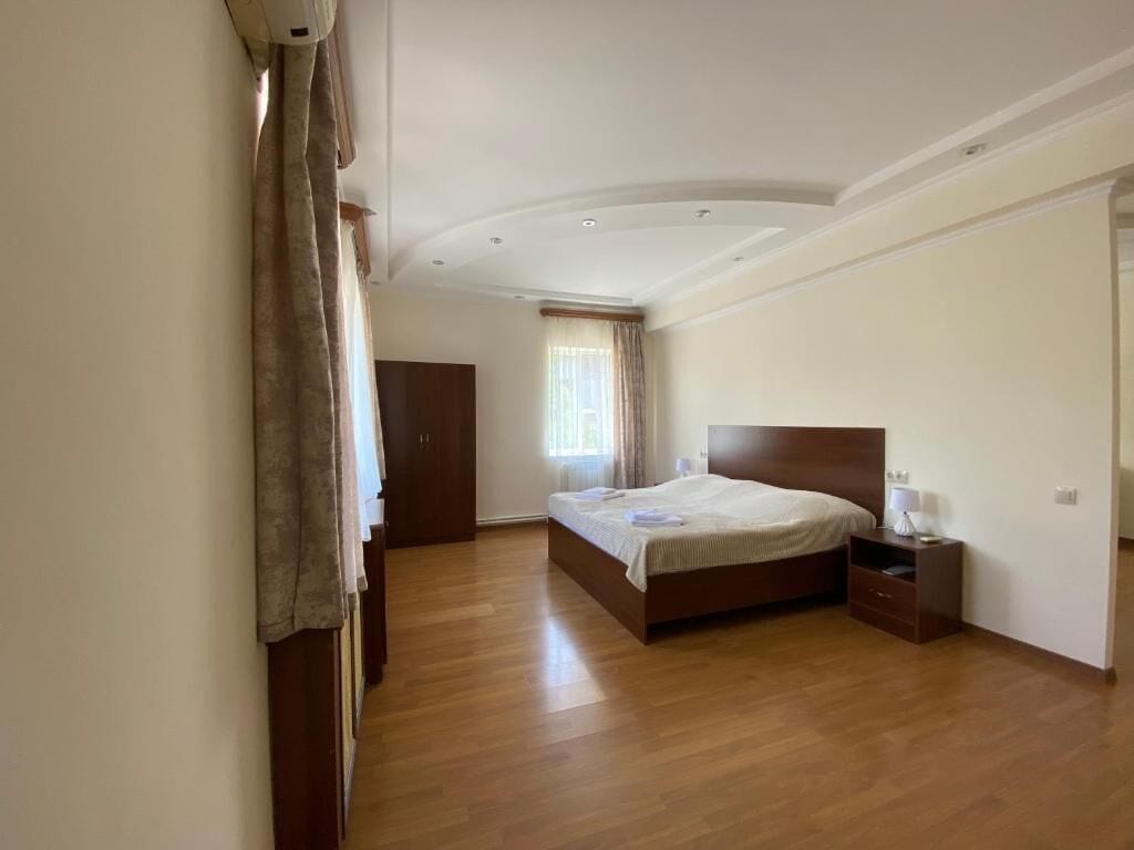 A bedroom with a bed, nightstand, and wardrobe.