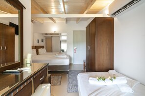 Ein Hotelzimmer mit einem großen Bett, einer separaten Sitzecke, einem Spiegel, einem Schreibtisch und einem Kleiderschrank.