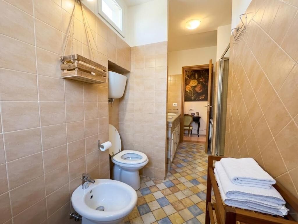 Une salle de bain comprenant des toilettes, un bidet, un lavabo et un porte-serviettes.