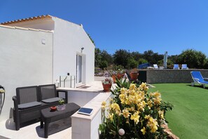 A patio with outdoor furniture, a white building, and a green lawn area. - Casa Susanne Country House with Private Pool, Wi-Fi, and Air Conditioning (Tunes)