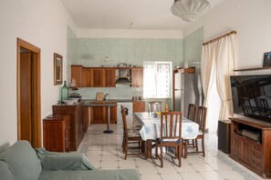 Un espacio habitable compacto con comedor, cocina y televisor.