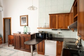 Una cocina con armarios de madera, lavavajillas, microondas y fregadero.