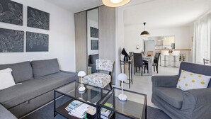 Uma sala de estar moderna com um sofá, poltronas, uma mesa de centro e obras de arte nas paredes.