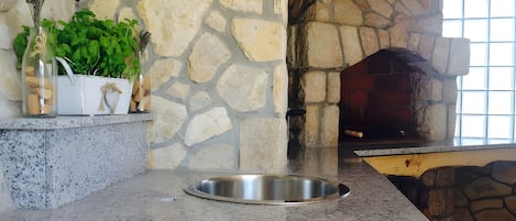 A kitchen with a stone wall, a built-in oven, and a granite countertop.