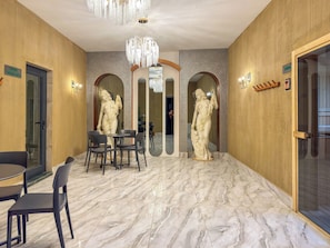 A hotel lobby with marble flooring, a chandelier, and two statues. - Qoople Green Ocean B55 2-bedroom apartment in serene Alanya (Alanya)