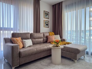 Ein modernes Wohnzimmer mit einer Couch, einem Couchtisch und Blick auf die Stadt.
