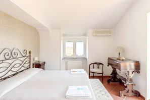 A hotel room with a bed, a desk, a chair, and a window. - Holiday Home 'Alexandra' with Sea View, Wi-Fi and Air Conditioning (Vico Equense)