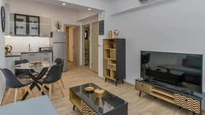 Un espacio moderno para vivir con comedor, cocina y mueble de entretenimiento.