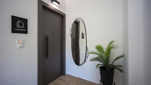 Un pasillo con una puerta, un espejo en la pared, una planta en maceta y un letrero que dice 'Ceramicist'.