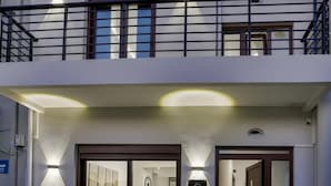 Un edificio de dos pisos con un balcón, iluminado por varias luces del techo.
