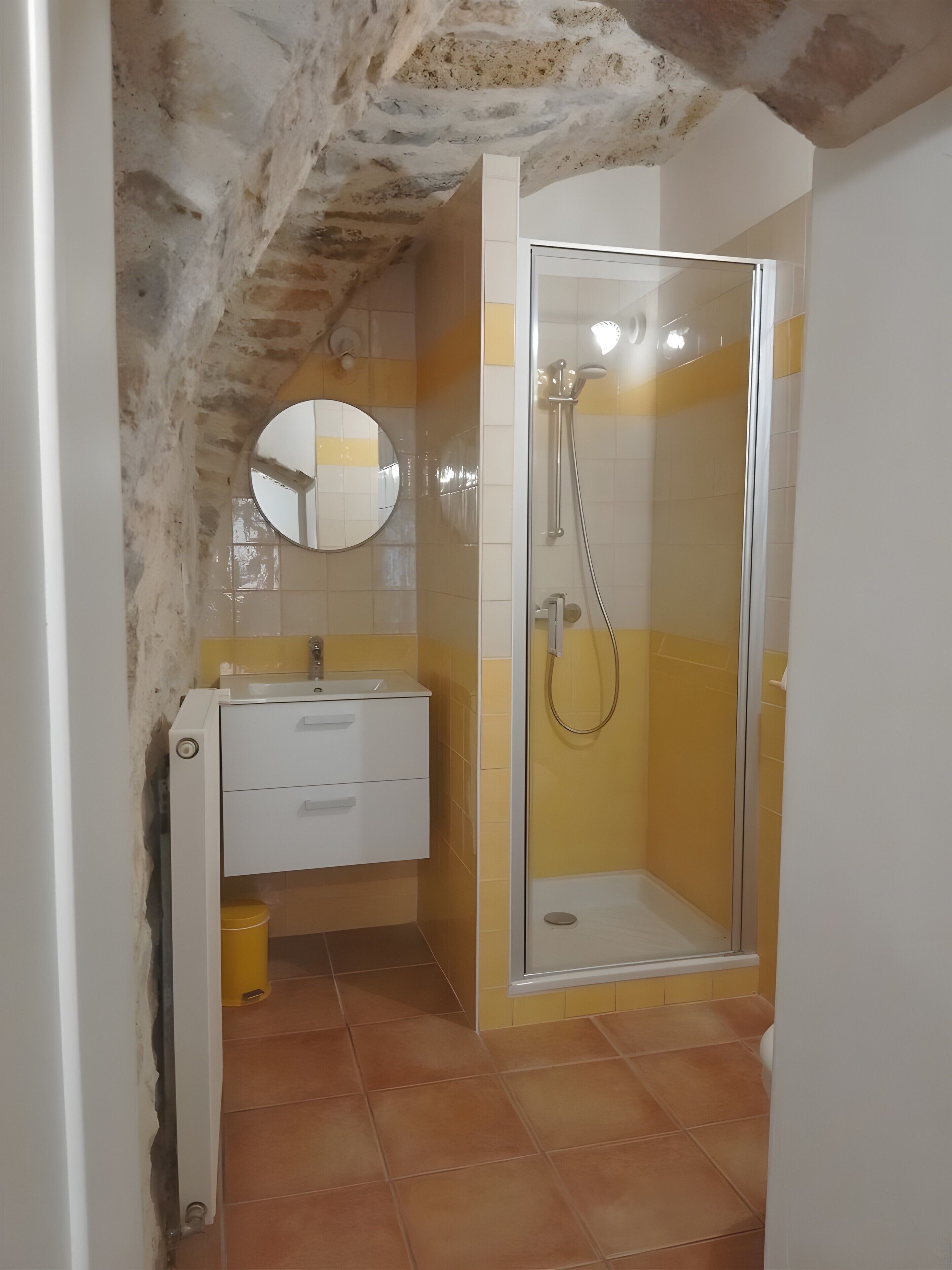 Un baño con ducha, lavabo y espejo.