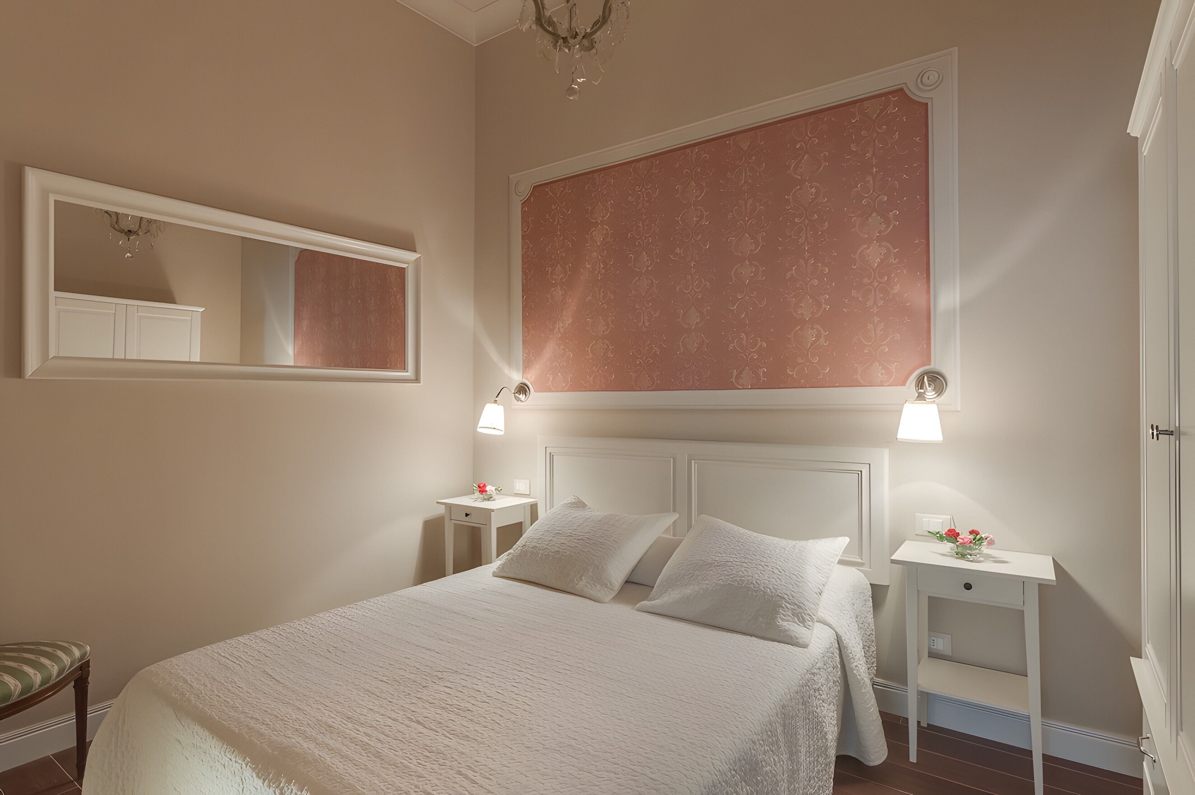 A bedroom with a large bed, two bedside tables, a nightstand, a mirror, and a decorative panel on the wall.