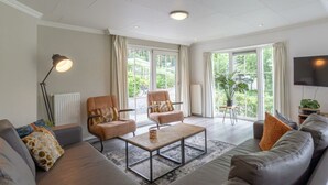 A modern living room with a sofa, two armchairs, a coffee table, and a TV. - Hackfort L"etage 10 (Brunssum)