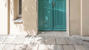 A building with a teal double door, a small window, and a number '13' sign. - A Functional Studio in the City Centre | Stary Browar (Poznań)