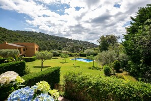 Une propriété résidentielle dotée d’une piscine, d’une végétation luxuriante et située au pied d’une colline.