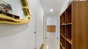 A hallway with a wooden bookshelf, a large mirror, and a tiled floor. - Apartment 'Portatrastevere' with Balcony, Wi-Fi and Air Conditioning (Rome)