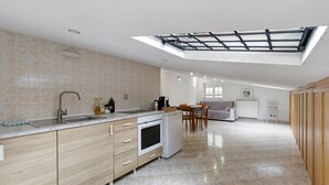 A modern kitchen with a skylight, a dining area, and a view of the living room. - Apartment 'Portatrastevere' with Balcony, Wi-Fi and Air Conditioning (Rome)