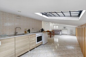 Uma cozinha moderna com claraboia, área de jantar e vista para a sala de estar.