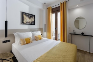 A hotel room with a bed, a round mirror, a small table, and a window with curtains. - Apartment 'Ceramicist' with Shared Terrace, Wi-Fi and Air Conditioning (Heraklion)