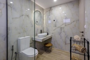 A bathroom with a toilet, sink, and glass-enclosed shower area. - Apartment 'Ceramicist' with Shared Terrace, Wi-Fi and Air Conditioning (Heraklion)