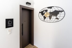 A door, a world map clock, and a sign with a house icon and the word 'Polisher'. - Apartment 'Ceramicist' with Shared Terrace, Wi-Fi and Air Conditioning (Heraklion)