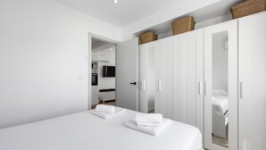 A modern hotel room with a large bed, a wardrobe, and a bathroom visible through an open door. - Apartment 'Copenhague - 049' with Mountain Views, Wi-Fi, and Air Conditioning (Torre del Mar)
