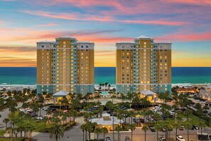A hotel with a pool, parking, and a view of the ocean. - Relax Above the Emerald Coast | Luxury 2BR Gulf-Front Retreat (Panama City Beach)