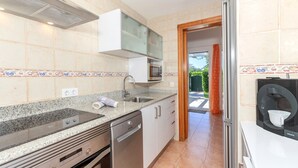 A modern kitchen with a dishwasher, oven, and a microwave. - Holiday Home 'Villa Jaume' with Private Pool, Private Garden and Air Conditioning (Cap d'Artrutx)