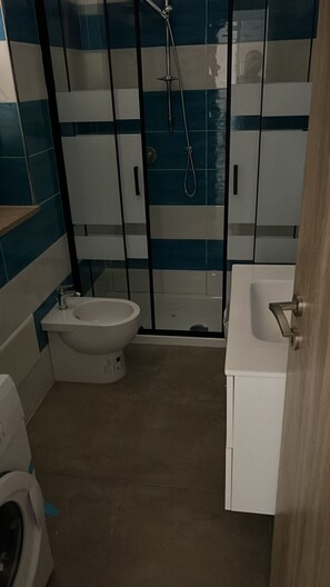 Kylpyhuone, jossa on wc, suihku ja pesuallas.