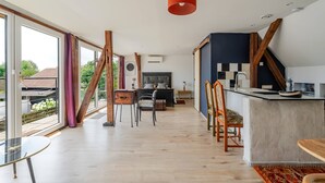 Una cocina moderna con una isla grande, vigas de madera y vistas al exterior.