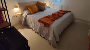 A bedroom with a bed, pillows, a bedside table, a hanging light fixture, and a window with curtains. - Room 'Bovoletto Camera Doppia - Aqua Alta' with Wi-Fi and Air Conditioning (Chioggia)