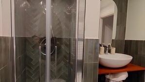 A modern bathroom with a glass-enclosed shower, a white sink, and a mirror above it. - Room 'Bovoletto Camera Doppia - Aqua Alta' with Wi-Fi and Air Conditioning (Chioggia)