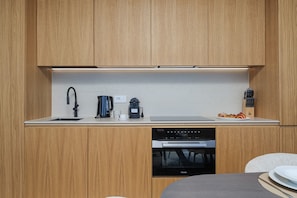 Een moderne keuken met houten kastjes, een ingebouwde vaatwasser en een koffiezetapparaat.