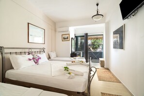 A hotel room with two beds, a balcony, and a TV. - Room 'Triple  113' with Shared Terrace, Wi-Fi and Air Conditioning (Nikiana)