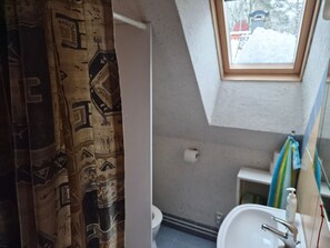 Een badkamer met toilet, wastafel en raam.