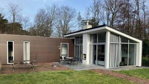 A modern house with a patio, a dining area, and a large glass door. - Holiday Home in Brunssum With Terrace (Brunssum)